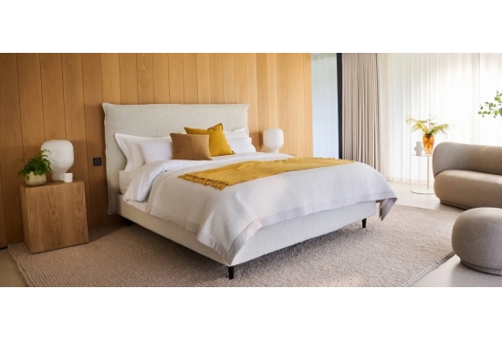 Air storage bed on slim legs in a calm bedroom, shown in boucle with an optional headboard