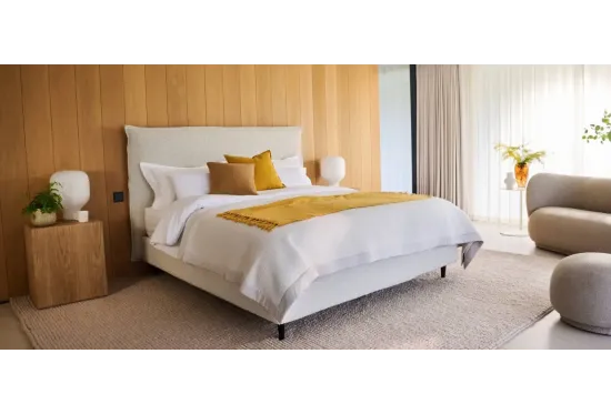 Air storage bed on slim legs in a calm bedroom, shown in boucle with an optional headboard