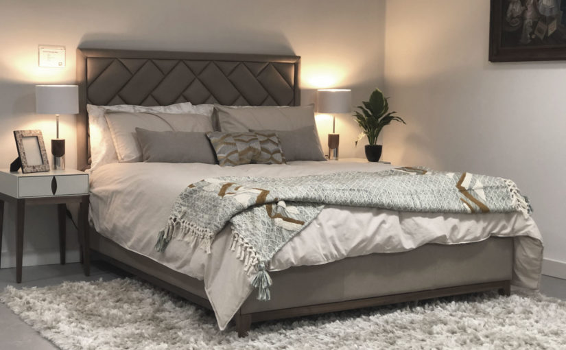 Bed dressed with a throw and scatter cushions