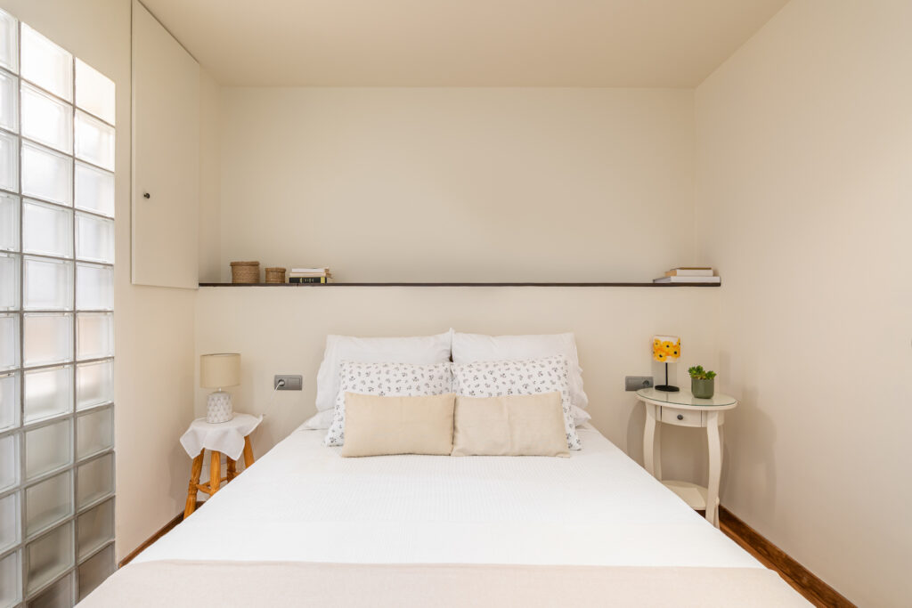 Bed with a shelf above it and no headboard