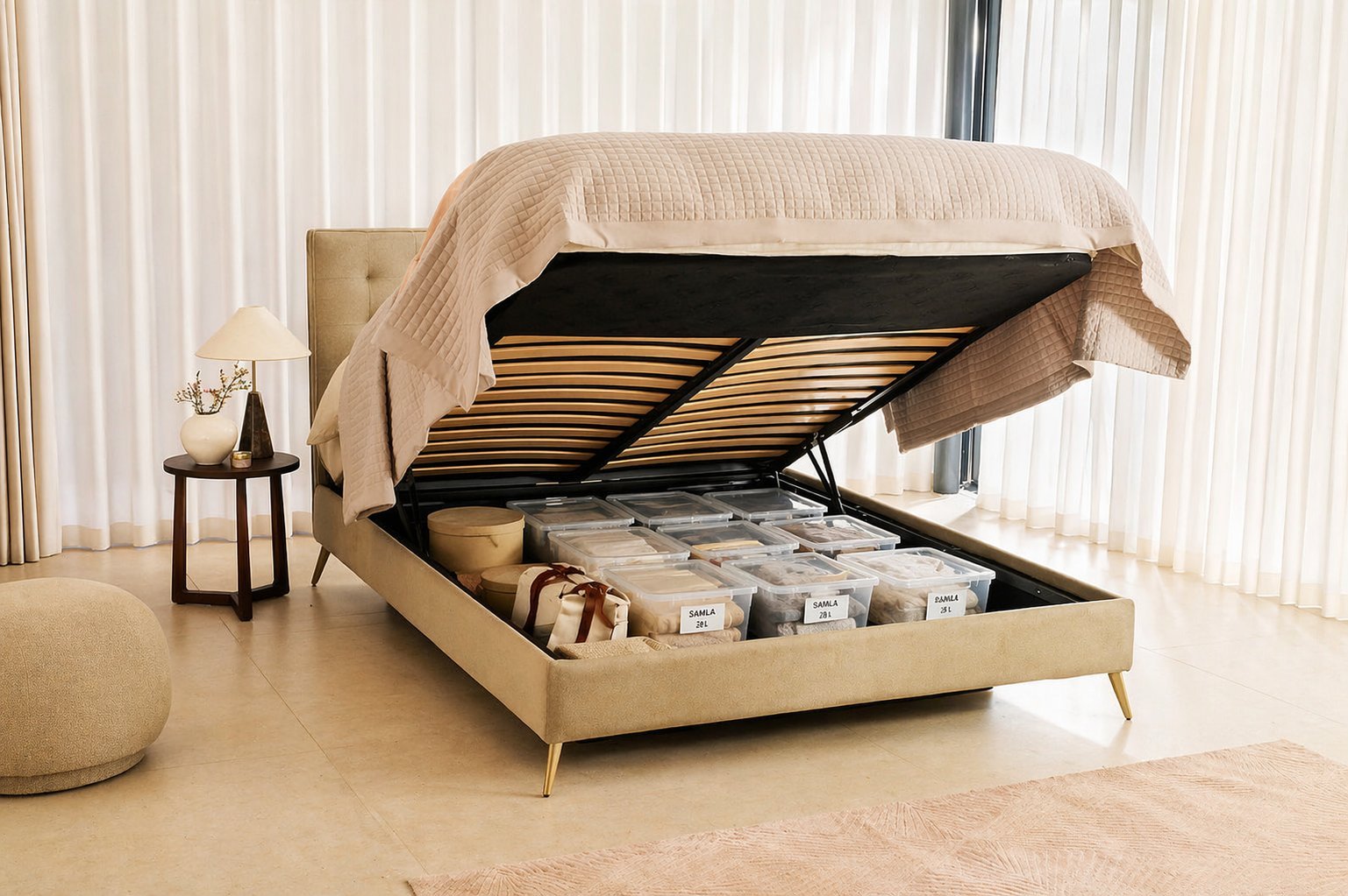 A Furl storage bed open on its ottoman mechanism, showing labelled IKEA SAMLA storage boxes arranged neatly underneath the mattress in a calm, neutral bedroom